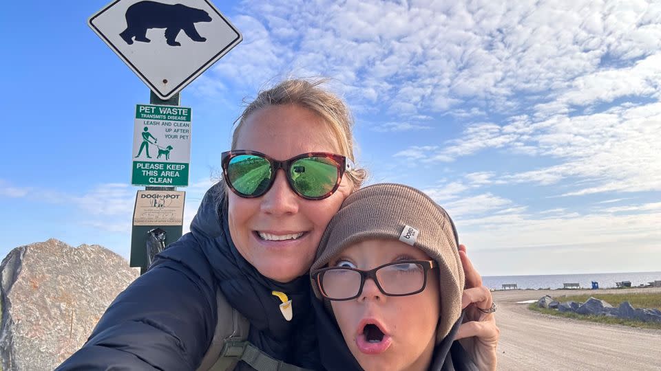 Terry Ward and her son take a selfie in front of a warning sign near Churchill’s city beach, fronting Hudson Bay. - Terry Ward