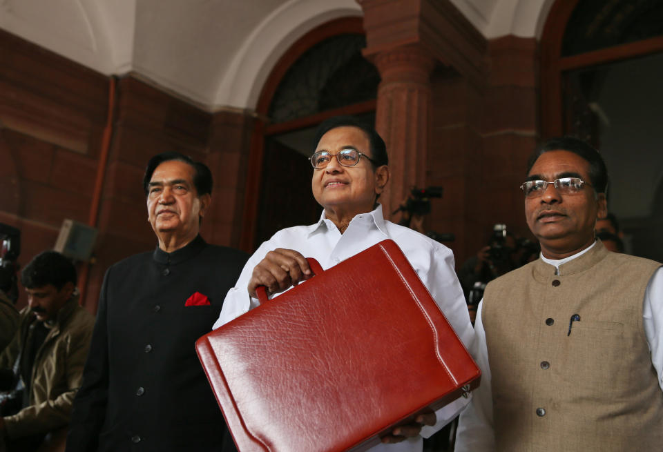 Indian Finance Minister P. Chidambaram, center, shows a briefcase containing interim budget for the fiscal year 2014-15, with state ministers of finance Namo Narain Meena, left, and J.D. Seelam as they arrive at parliament in New Delhi, India, Monday, Feb. 17, 2014. Chidambaram unveiled a conservative budget for the government’s remaining time in office through May. He said the government has narrowed its fiscal deficit and pledged to keep government spending at the same level. (AP Photo/Manish Swarup)