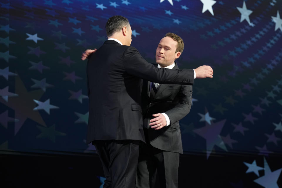 Cole Emhoff hugs his father on the second day of the Democratic National Convention.