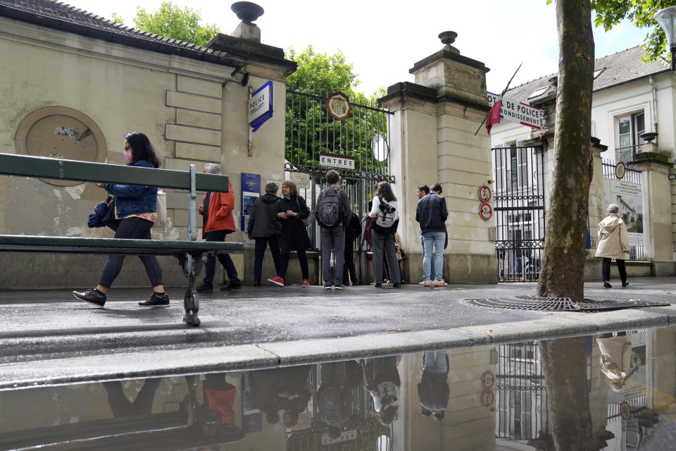 People queue outside a police station to fill out forms to vote by proxy, prior to the upcoming parliamentary elections in Paris, Wednesday, June 8, 2022. The legislative elections will take place on June 12 and 19, 2022. (AP Photo/Francois Mori)