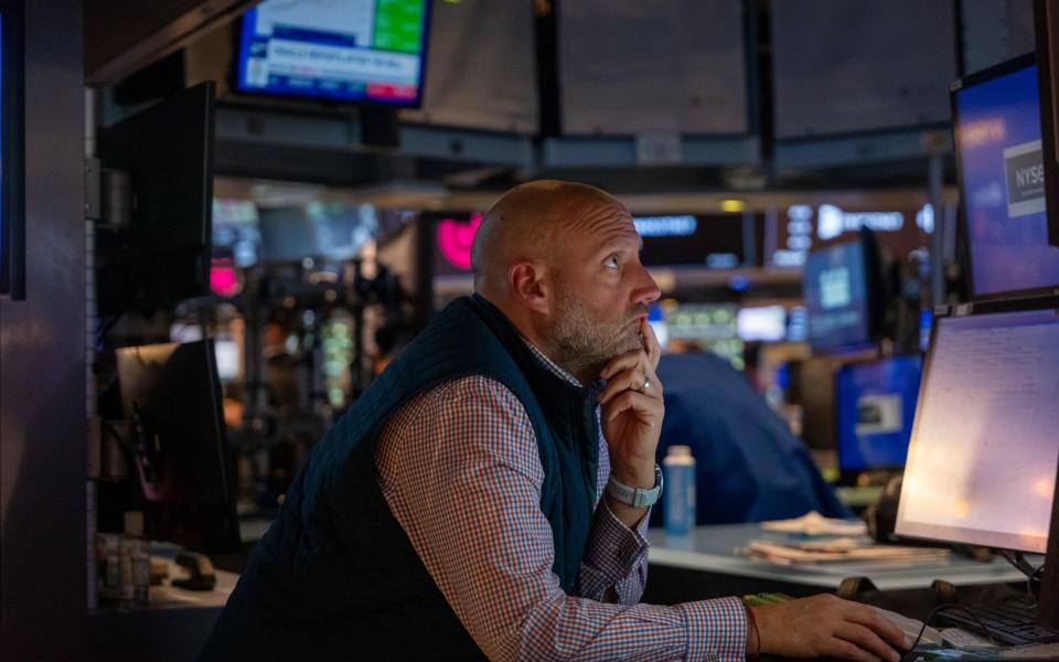 A trader on the New York Stock Exchange floor yesterday