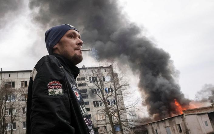 A local resident smokes near a buildings damaged by a Russian military strike in the city of Chasiv Yar, in Donetsk - STRINGER/REUTERS