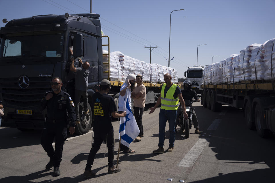 People block a road as they try to stop the trucks, carrying humanitarian aid, to enter in the Gaza Strip in an area near the Kerem Shalom border crossing between Israel and Gaza, in southern Israel, in Kerem Shalom, Thursday, May 9, 2024. (AP Photo/Leo Correa)
