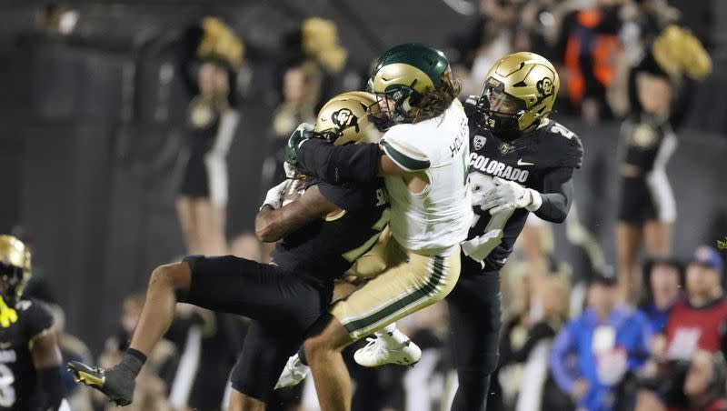 Colorado safety Cam’Ron Silmon-Craig, left, intercepts a pass intended for Colorado State tight end Dallin Holker, center, as Colorado safety Shilo Sanders joins in the coverage in the second half of a game on Saturday, Sept. 16, 2023, in Boulder, Colo.