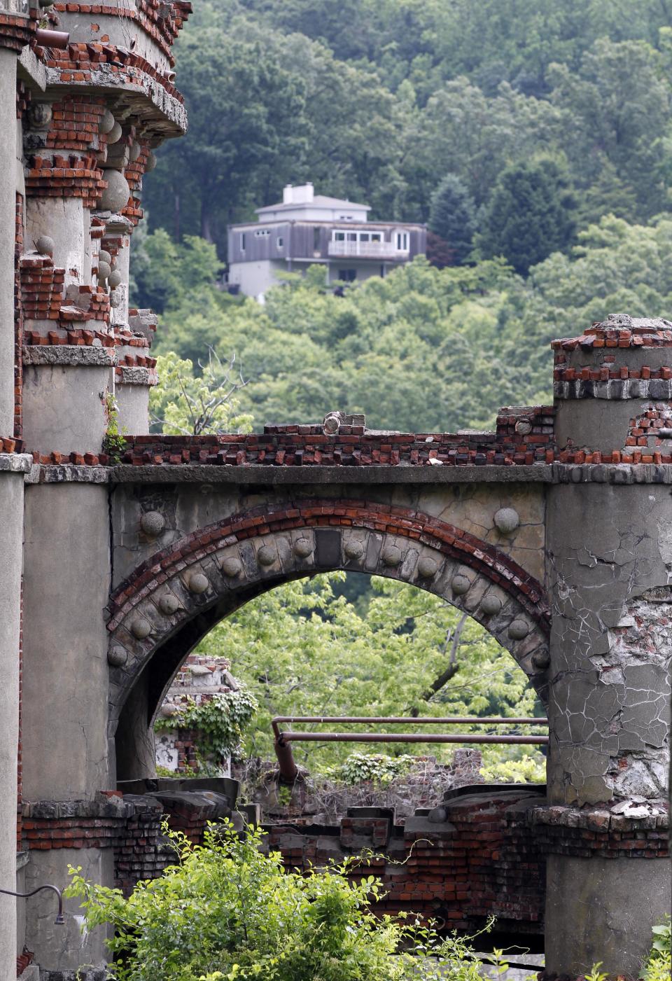 A house is seen beyond the Bannerman's Island Arsenal on Pollepel Island, N.Y., on Tuesday, June 5, 2012. Though it looks like it was built to withstand battering rams, it was actually a surplus military goods warehouse made to resemble a Scottish castle. Businessman Francis Bannerman VI had it built early in the 20th century as a place to store helmets, haversacks, mess kits and munitions he could not store in his thriving shop in Manhattan. (AP Photo/Mike Groll)