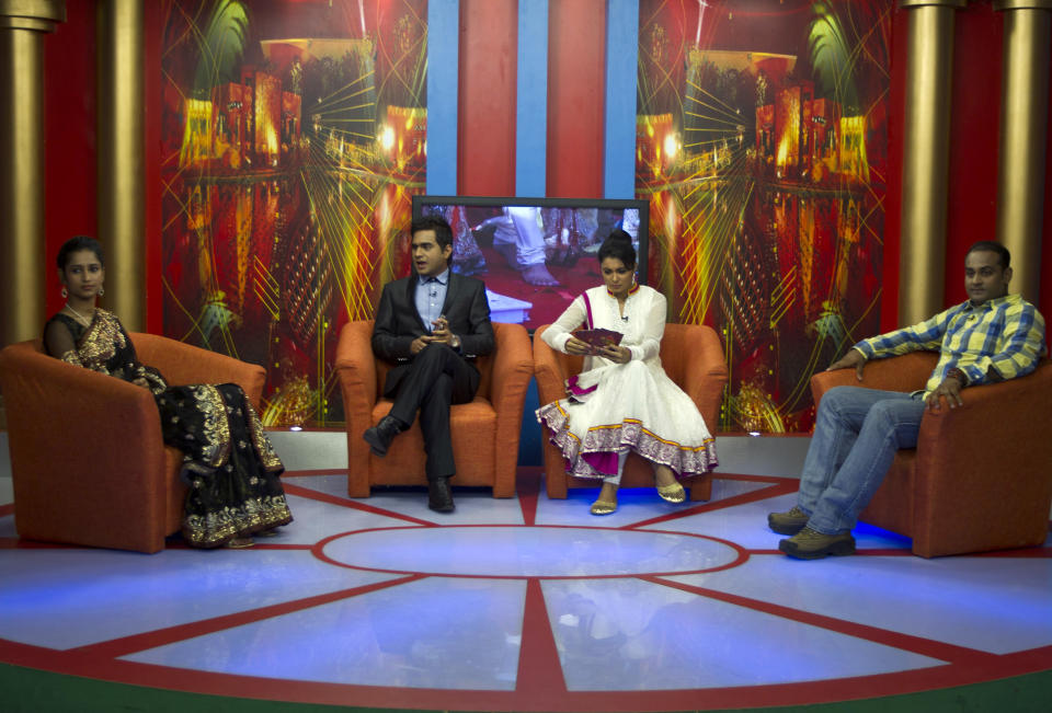 In this July 26, 2013 photo, Nidhi Gaur, far left and her fiance Rahul Rai, far right, participate in "So It's Final," a talk show on Shagun TV that features engaged couples in Noida, India. Indians are obsessed with weddings and obsessed with reality television. Now Shagun TV, a new television channel headquartered in a sprawling suburb of India's capital, is hoping it has found a can't-miss idea — merging the two into a 24-hour matrimonial TV station.(AP Photo/Tsering Topgyal)