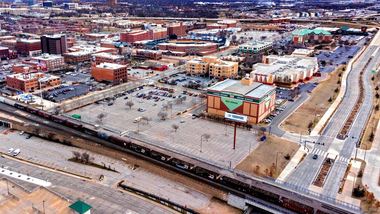 A hotel, three apartment towers, two garages, restaurants, retail and entertainment are planned to be built on the surface parking lot surrounding the U-Haul warehouse in Lower Bricktown.