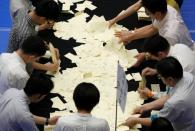 Election officers count votes at a ballot counting centre for Japan's upper house election in Tokyo