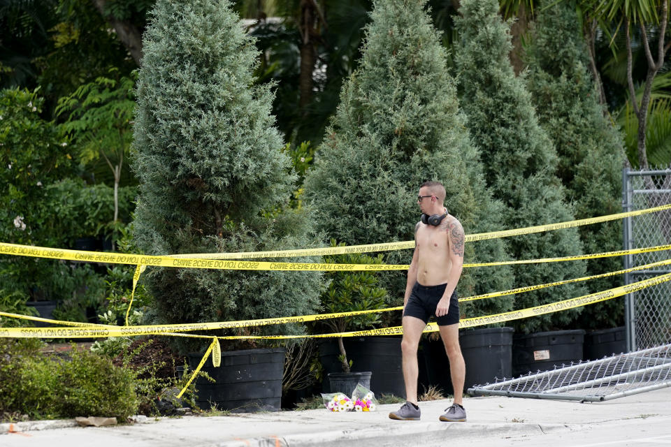 A man walks past the scene where a driver slammed into spectators at the start of a Pride parade Saturday evening, killing one man and seriously injuring another, Sunday, June 20, 2021, in Fort Lauderdale, Fla. Officials said the crash was an accident, but it initially drew speculation that it was a hate crime directed at the gay community. The driver and victims were all members of the Fort Lauderdale Gay Men's Chorus, who were participating in the Wilton Manors Stonewall Pride Parade. (AP Photo/Lynne Sladky)