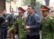 PVC's former chairman Trinh Xuan Thanh (C) is escorted by police to the court in Hanoi, Vietnam January 8, 2018. VNA/Doan Tan via REUTERS/Files