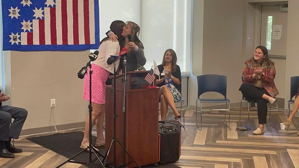 Veteran's Rally Point Director of Military Services Lori Marriot hugs U.S. Navy Corpsman Willow Clauson during the ribbon cutting for the expansion of the organization's food pantry Wednesday.