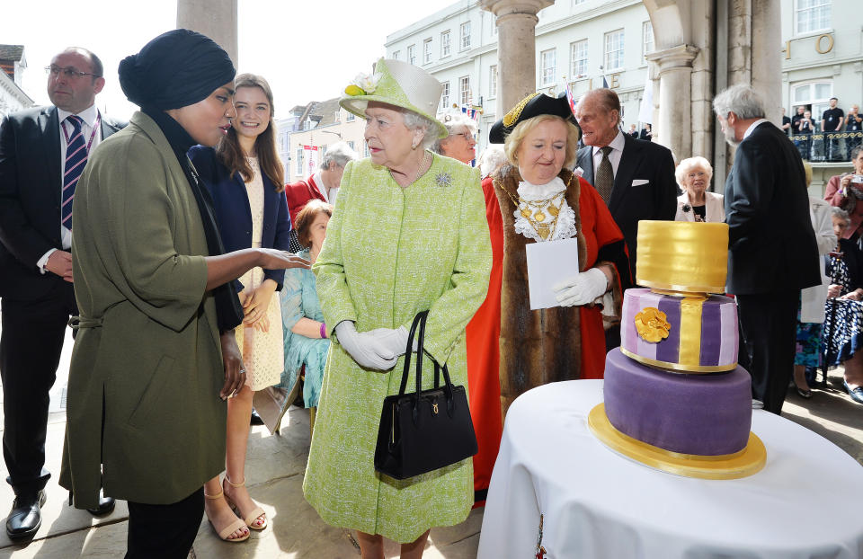 WINDSOR, ENGLAND - APRIL 21:  Queen Elizabeth II receives a birthday cake from Nadiya Hussain, winner of the Great British Bake Off, during her 90th Birthday Walkabout on April 21, 2016 in Windsor, England. Today is Queen Elizabeth II's 90th Birthday. The Queen and Duke of Edinburgh will be carrying out engagements in Windsor.  (Photo by John Stillwell - WPA Pool/Getty Images)