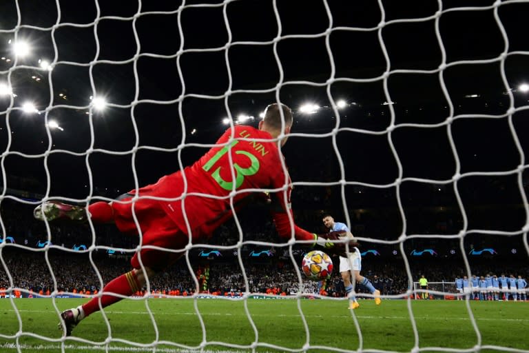 El guardameta ucraniano del Real Madrid Andriy Lunin se lanza para detener el penal lanzado por el centrocampista croata del Manchester City Mateo Kovacic en la tanda de penales de la vuelta de cuartos de final de Liga de Campeones, el 17 de abril de 2024 en Mánchester (DARREN STAPLES)