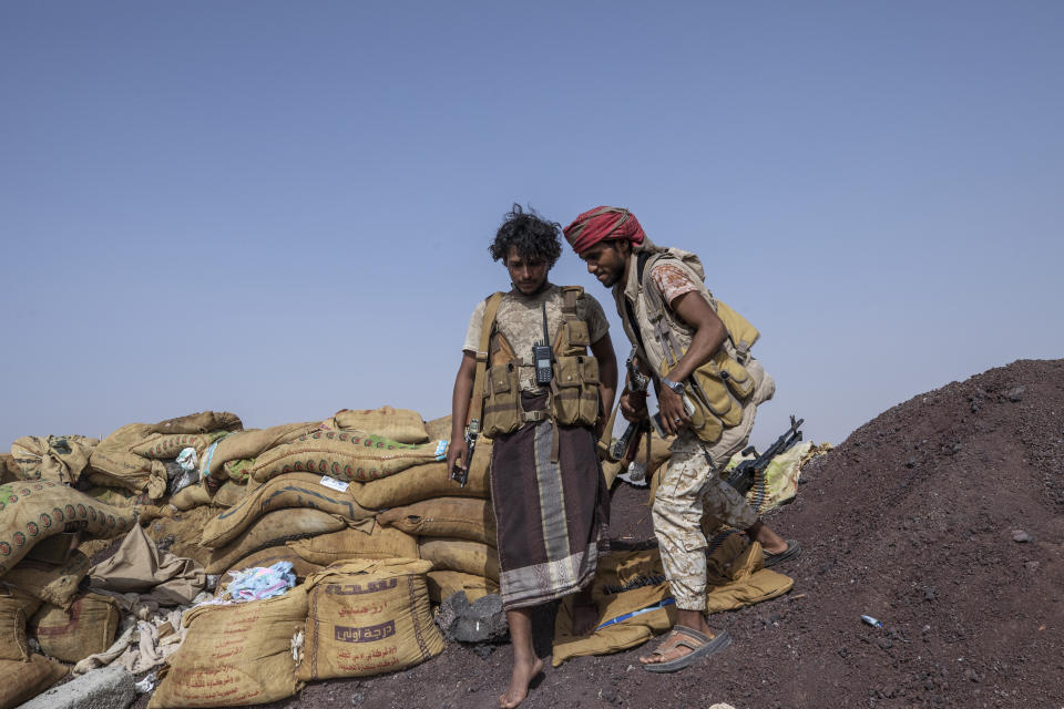 Yemeni fighter Hassan Saleh, left, and his younger brother Saeed backed by the Saudi-led coalition prepare to leave after clashes with Houthi rebels on the Kassara front line near Marib, Yemen, Sunday, June 20, 2021. The brothers, both in their early 20s, have been fighting alongside other government fighters and tribesman outside the oil-rich city of Marib against the months-long offensive by the Iranian-backed rebels. They say they need more weapons to push the attackers back. (AP Photo/Nariman El-Mofty)