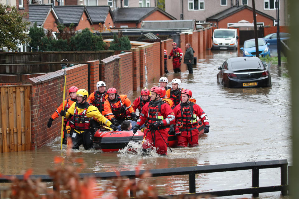 Fire and Rescue service members pull an inflatable boat that has been used to rescue residents trapped by floodwater in in Doncaster, Yorkshire, as parts of England endured a month's worth of rain in 24 hours, with scores of people rescued or forced to evacuate their homes, others stranded overnight in a shopping centre, and travel plans thrown into chaos.