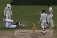 England's Kevin Pietersen (bottom) lies on the ground after being hit by the ball next to Australia's captain Michael Clarke (top L) during the fourth day's play in the second Ashes cricket test at the Adelaide Oval December 8, 2013.