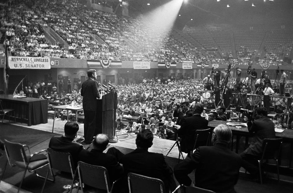 FILE - In this Aug. 21, 1960 file photo, illuminated by a spotlight, Sen. John F. Kennedy, Democratic presidential nominee, speaks to an audience in Des Moines, Iowa. (AP Photo)