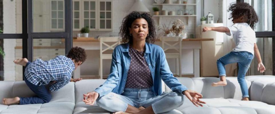 Mom meditating while kids run around