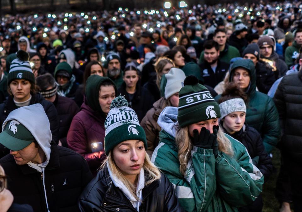 People stand together during a vigil at The Rock on the Michigan State University campus in East Lansing on Wednesday, February 15, 2023, to honor and remember the victims of the mass shooting that happened on the MSU campus that left three dead and multiple others injured. 