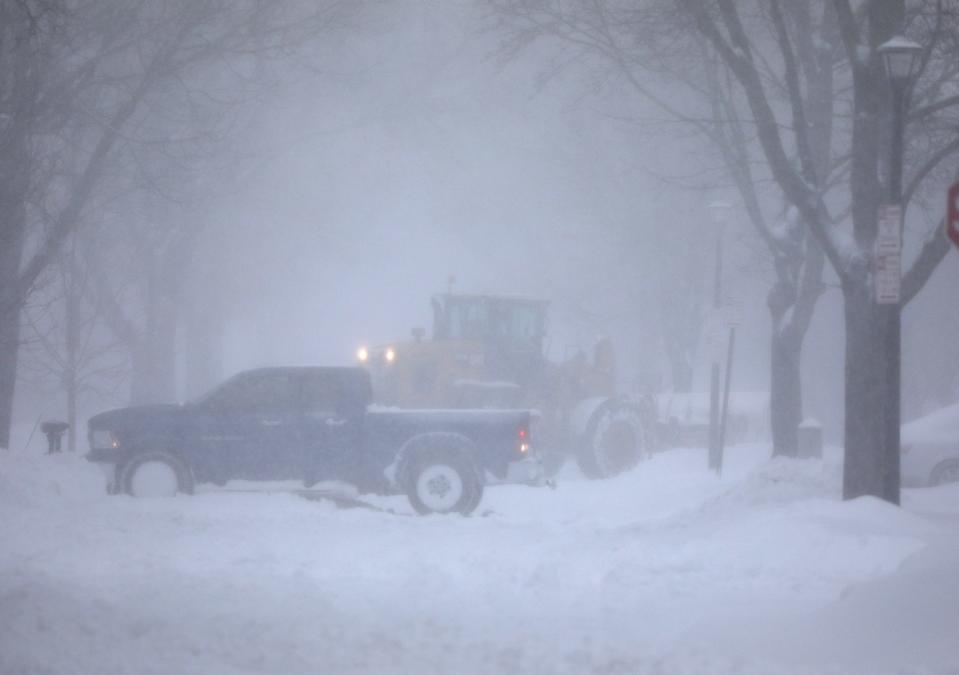 A private plow, digging out a driveway on Wellington Avenue in Rochester, and a city plow look like they are passing each other as they both work on snow removal on Monday, January 17, 2022. 