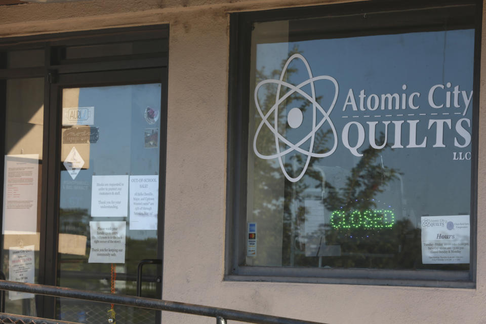 A storefront window announces a work hiatus on Thursday, May 12, 2022, as residents of Los Alamos, N.M., prepared to possibly flee a wildfire as it crept within a few miles of the city and companion national security laboratory. Scientists at Los Alamos National Laboratory are using supercomputers and ingenuity to improve wildfire forecasting and forest management amid drought and climate change in the American West. (AP Photo/Morgan Lee)