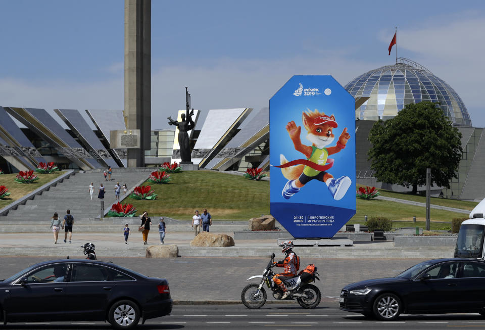 In this photo taken on Wednesday, June 19, 2019, people pass by advertisement billboard in Minsk, Belarus. Shrunken in size and struggling for attention, the European Games open Friday in Belarus which is one of the continent’s most isolated countries. There was a lavish inaugural event in Azerbaijan four years ago with the opening ceremony alone costing $95 million and starring Lady Gaga. But it wasn’t enough to attract many big-name athletes to Minsk for this year’s event. (AP Photo/Sergei Grits)