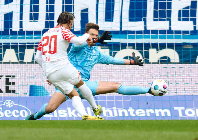 Bochum goalkeeper Andreas Luthe saves against Leipzig's Xavi Simons (L) during the German Bundesliga soccer match between VfL Bochum and RB Leipzig at Vonovia Ruhrstadion. Bernd Thissen/dpa