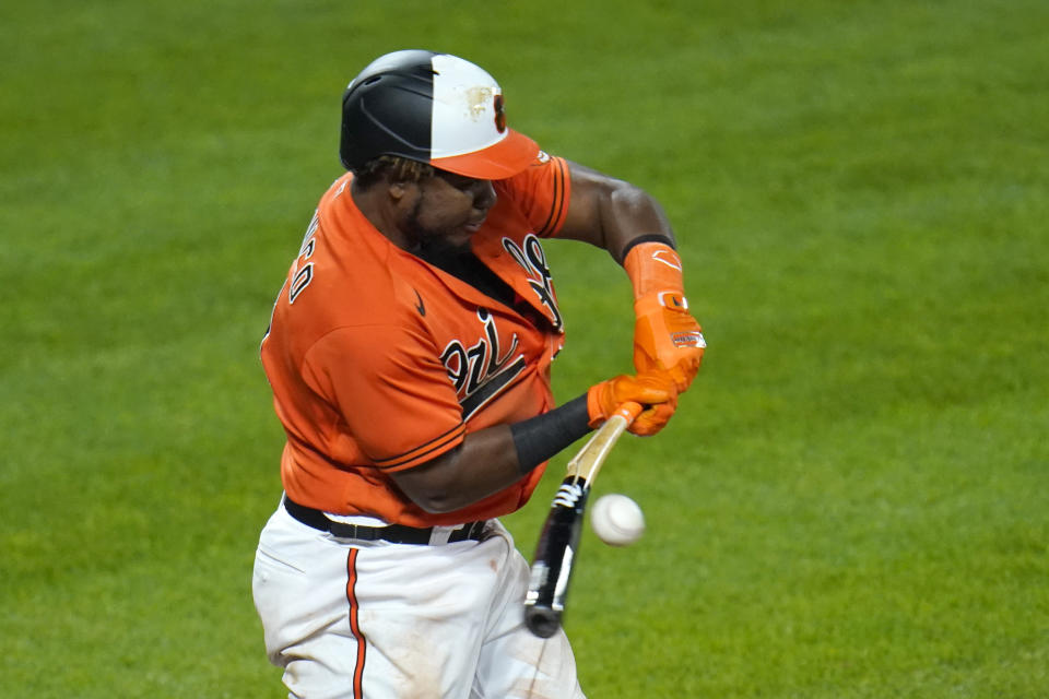 Baltimore Orioles' Maikel Franco breaks his bat while driving in Ryan Mountcastle with a run against the Boston Red Sox during the eighth inning of a baseball game, Saturday, April 10, 2021, in Baltimore. The Red Sox won 6-4 in ten innings. (AP Photo/Julio Cortez)