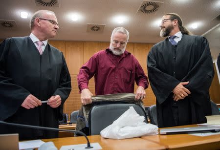 Defendant Swiss man Daniel M., accused of spying on a German tax authority to find out how it obtained details of secret Swiss bank accounts set up by Germans to avoid tax, stands next to his lawyers Hannes Linke (L) and Anwalt Robert Kain (R) before the start of his trial on espionage charges, in the Higher Regional Court in Frankfurt am Main, Germany October 18, 2017. REUTERS Andreas Arnold/Pool