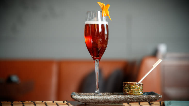 Kir cocktail in a flute glass with lemon twist