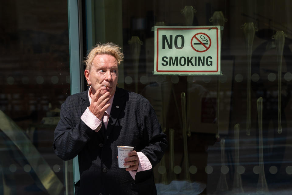 John Lydon, aka Johnny Rotten, smokes outside the Rolls Building at the High Court, London, where he is giving evidence in a hearing between two former Sex Pistols band members and the frontman over the use of their songs in a television series. Picture date: Wednesday July 21, 2021. (Photo by Dominic Lipinski/PA Images via Getty Images)