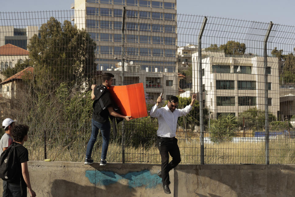 A Palestinian protester scuffles with rabbi Yonatan Yosef, a right-wing Jewish activist, during a demonstration in the Sheikh Jarrah neighborhood of east Jerusalem, where dozens of Palestinian families, face imminent forcible eviction from their homes by Israeli settlers, Friday, May 28, 2021. After weeks of unrest that captured international attention, the evictions could still proceed. Some could be carried out in the coming months as international attention wanes, potentially setting off another round of bloodshed. (AP Photo/Maya Alleruzzo)