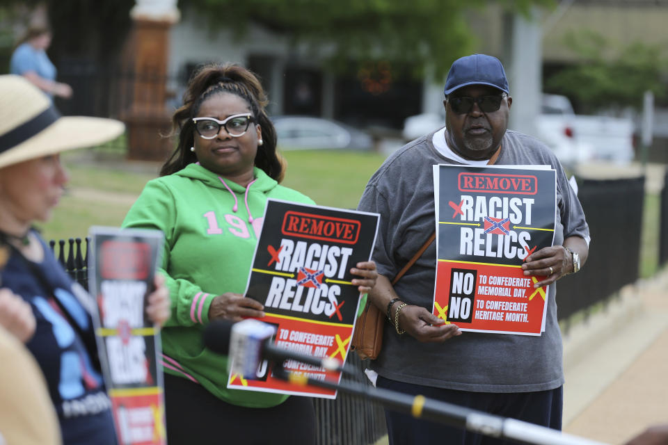 CORRECTS FACTUAL ERRORS AND REMOVES REFERENCE TO CONFEDERATE MEMORIAL DAY BEING NEW AS IT IS NOT NEW IN STATE LAW - Daniel Jenkins and members of Indivisible Northeast Mississippi and Concerned Citizens protest Confederate Memorial Day in front of a Confederate monument at the old Lee County Courthouse in Tupelo, Miss., Monday, April 25, 2022. The demonstrators called for an end to Confederate Heritage Month and Confederate Memorial Day in Mississippi. (Thomas Wells/The Northeast Mississippi Daily Journal via AP)