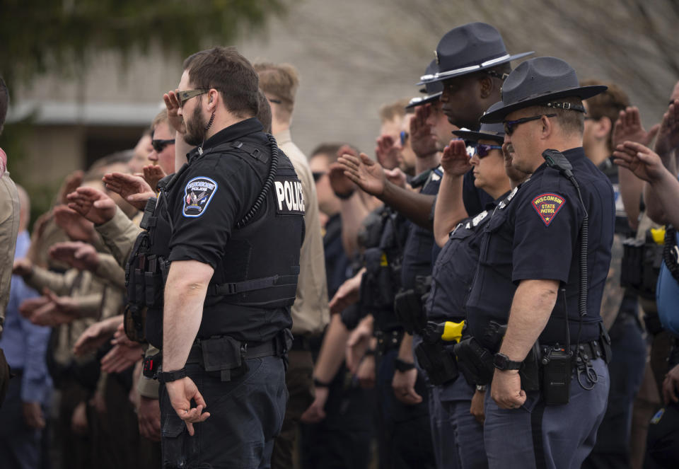 Law enforcement officers salute as St. Croix County Deputy Kaitie Leising's body is carried into a Baldwin, Wis., funeral home Sunday afternoon, May 7, 2023. Leising was shot and killed during a traffic stop Saturday. (Jeff Wheeler/Star Tribune via AP)