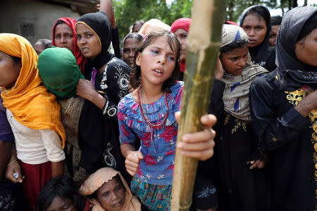 A Rohingya refugee girl looks exhausted due to extreme hot weather as she waits for humanitarian aid to be distributed at the Balu Khali refugee camp in Cox's Bazar, Bangladesh October 5, 2017. REUTERS/Mohammad Ponir Hossain