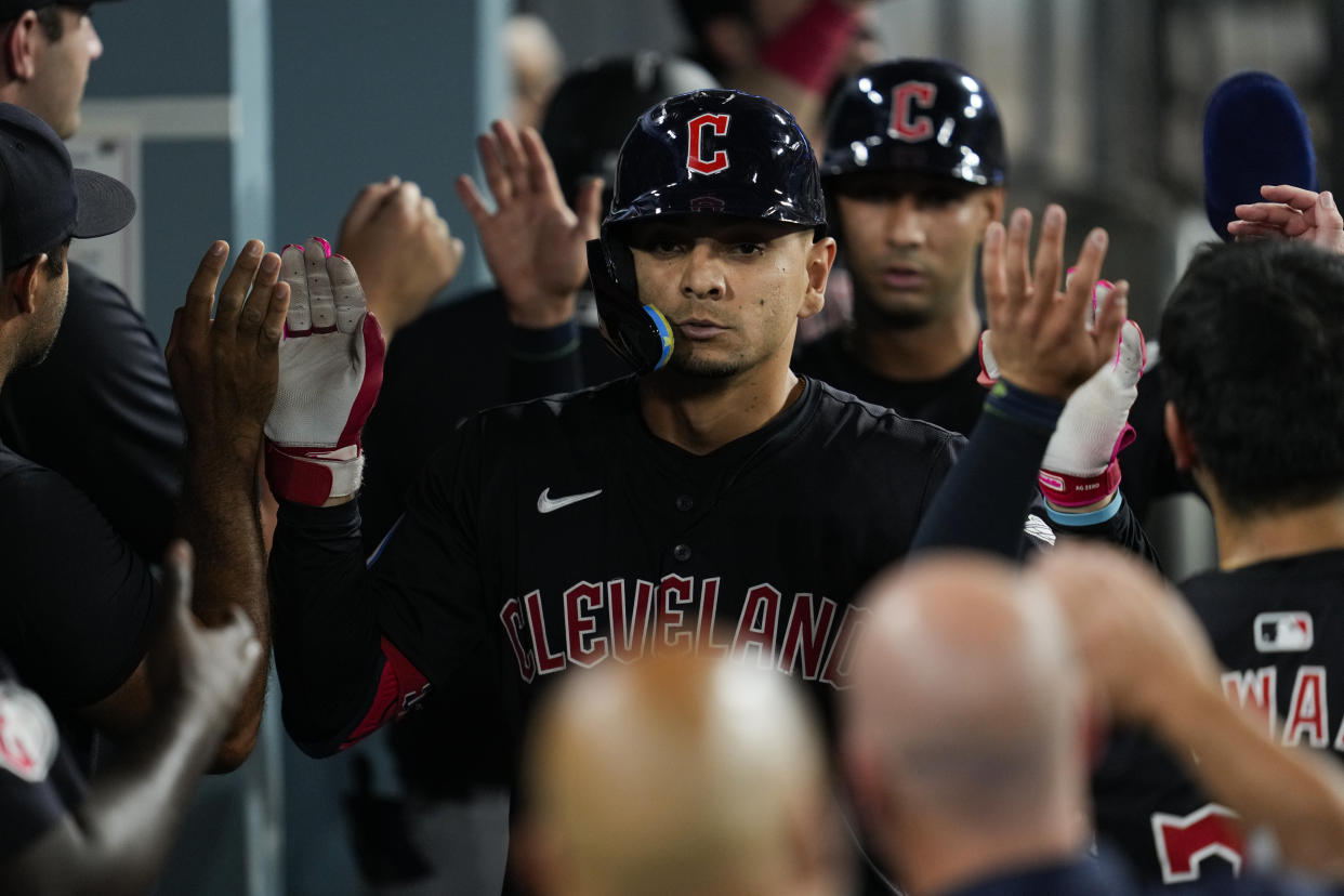 Cleveland Guardians' Andrés Giménez celebrates in the dugout after hitting a home run during the sixth inning of a baseball game against the Los Angeles Dodgers in Los Angeles, Friday, Sept. 6, 2024. Brayan Rocchio also scored. (AP Photo/Ashley Landis)