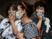 <p>Passersby cover their face as they walk near the fire site at Tokyo’s Tsukiji fish market in Tokyo, Japan August 3, 2017. (Photo: Toru Hanai/Reuters) </p>