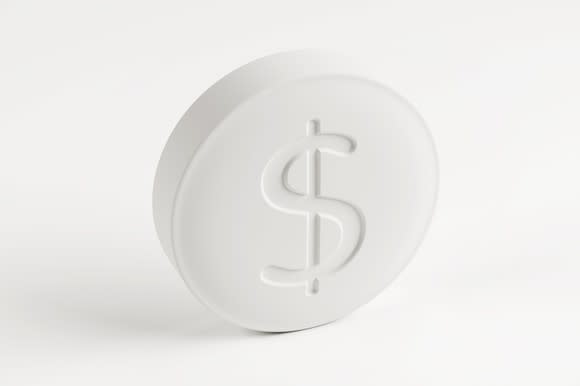 A white prescription tablet stamped with a dollar sign.