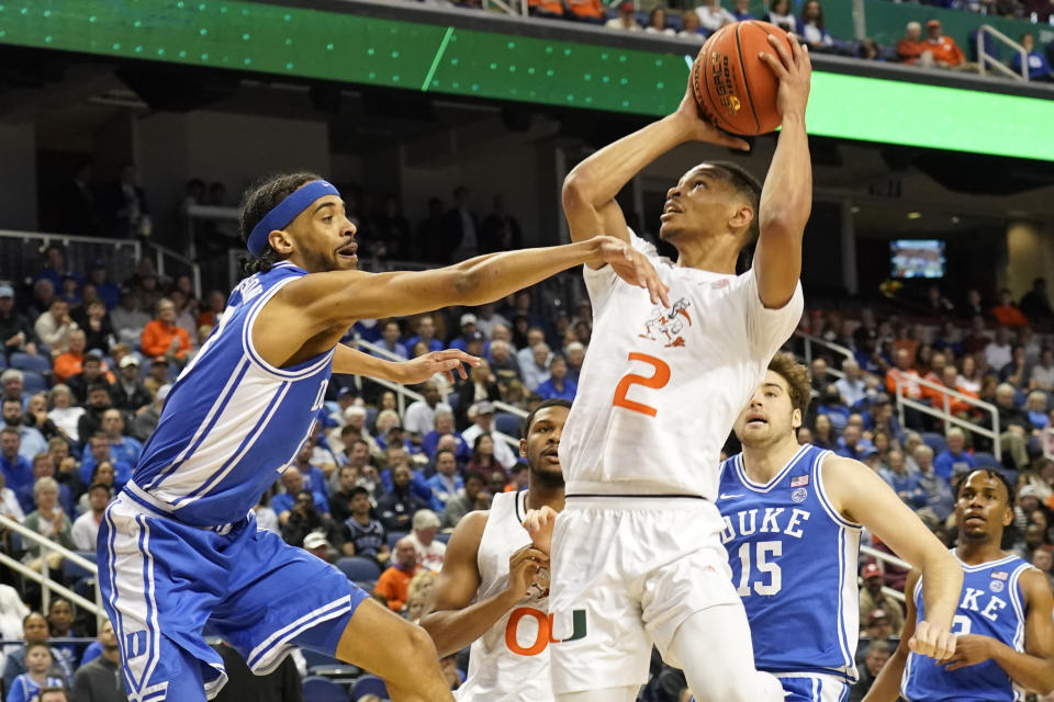 Miami's Isaiah Wong (2) shoots over Duke guard Jacob Grandison (13) during the first half of an NCAA college basketball game at the Atlantic Coast Conference Tournament in Greensboro, N.C., Friday, March 10, 2023. (AP Photo/Chuck Burton)