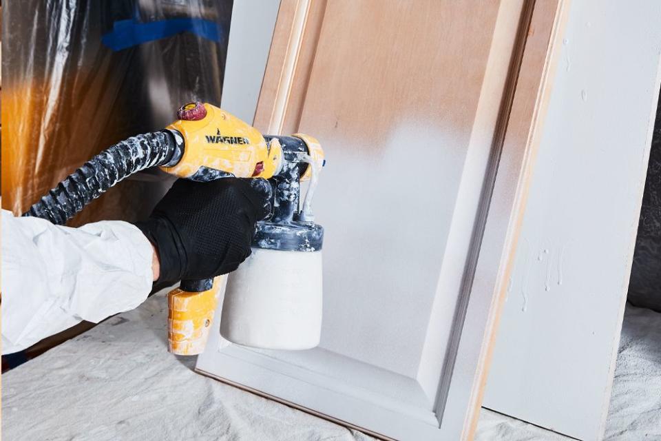 a person priming their kitchen cabinets