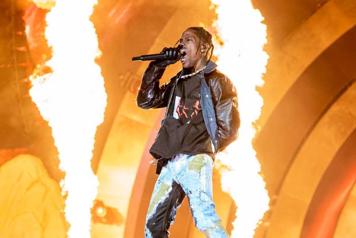 Travis performing onstage with flares of fire behind him