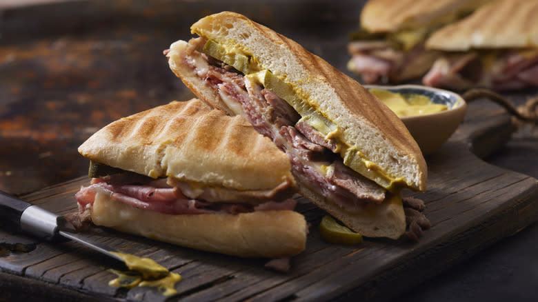 Cuban sandwich next to bowl of mustard 