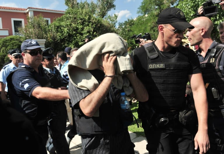 A Greek police officer escorts a Turkish officer who fled to Greece after the failed coup in Turkey, as he leaves a courthouse on July 21, 2016