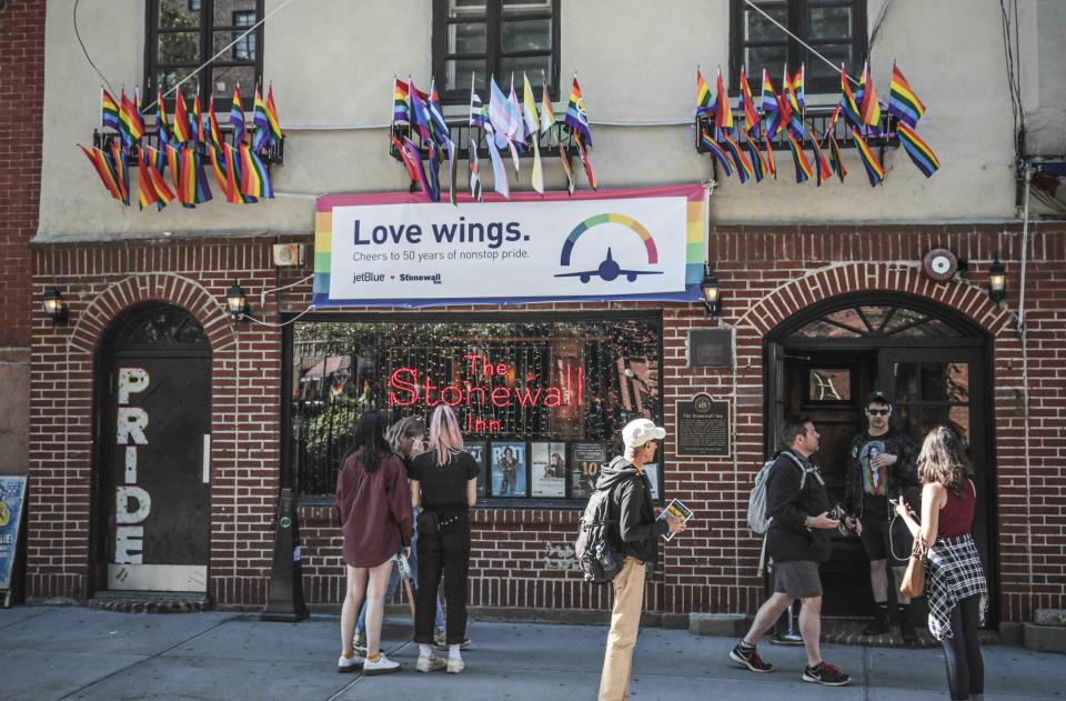 In this Monday, June 3, 2019, photo, pride flags and pride colors display on the Stonewall Inn bar, marking the site of 1969 riots that followed a police raid of the bar's gay patrons, in New York. Some of the coverage of rioting was itself a source of the fury that led Stonewall to become a synonym for the fight for gay rights.(AP Photo/Bebeto Matthews)