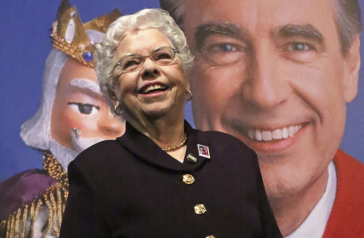 FILE - Joanne Rogers stands in front of a giant Mister Rogers Forever Stamp following the first-day-of-issue dedication in Pittsburgh on March 23, 2018. Rogers, the widow of Fred Rogers, the gentle TV host who entertained and educated generations of preschoolers on “Mister Rogers’ Neighborhood,” has died. She was 92. (AP Photo/Gene J. Puskar, File)