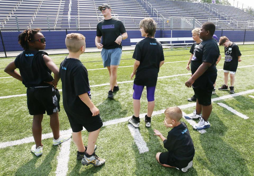John Cominsky, a former Barberton standout and current Detroit Lion, talks and jokes with campers Saturday during the John Cominsky Youth Football Camp at Rudy Sharkey Stadium in Barberton.