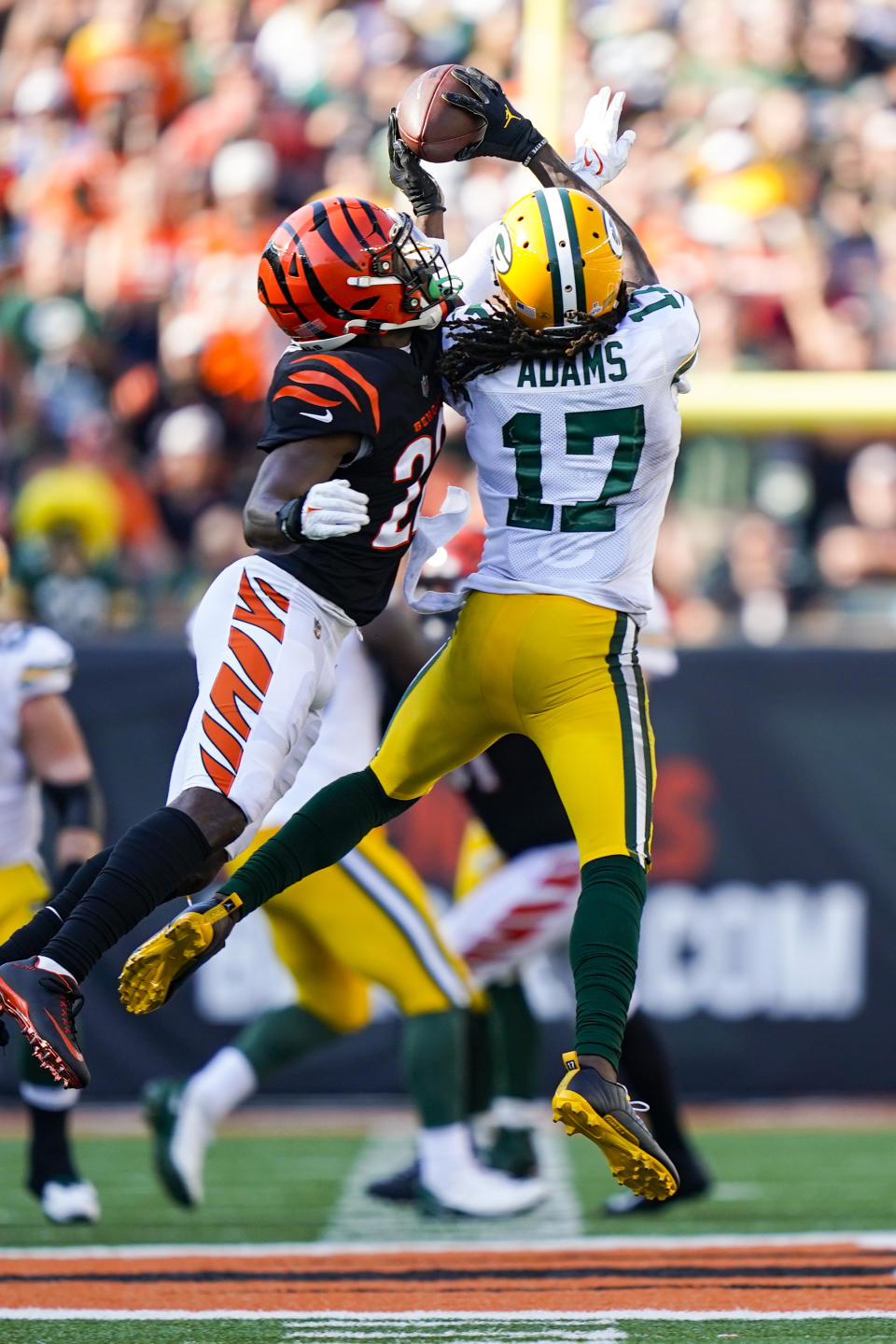 Green Bay Packers wide receiver Davante Adams (17) makes a catch over Cincinnati Bengals cornerback Chidobe Awuzie (22) in the second half of an NFL football game in Cincinnati, Sunday, Oct. 10, 2021. (AP Photo/Bryan Woolston)