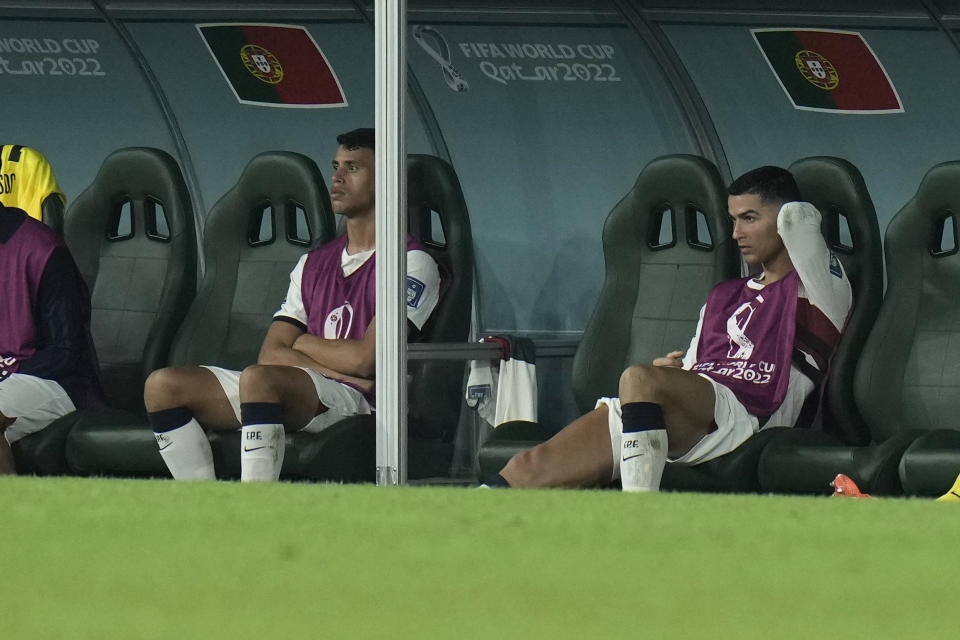 Portugal's Cristiano Ronaldo, right, sits on the bench during the World Cup group H soccer match between South Korea and Portugal, at the Education City Stadium in Al Rayyan , Qatar, Friday, Dec. 2, 2022. (AP Photo/Hassan Ammar)