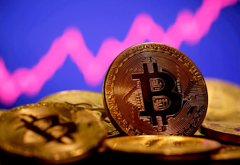 FILE PHOTO: A representation of virtual currency Bitcoin is seen in front of a stock graph in this illustration taken