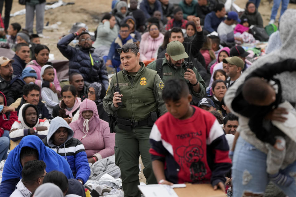 U.S. Border Patrol agents move through a crowd of migrants that have waited between two border walls for days to apply for asylum, as they decide who to take next to processing Friday, May 12, 2023, in San Diego. Hundreds of migrants remain waiting between the two walls, many for days. The U.S. entered a new immigration enforcement era Friday, ending a three-year-old asylum restriction and enacting a set of strict new rules that the Biden administration hopes will stabilize the U.S.-Mexico border and push migrants to apply for protections where they are, skipping the dangerous journey north. (AP Photo/Gregory Bull)